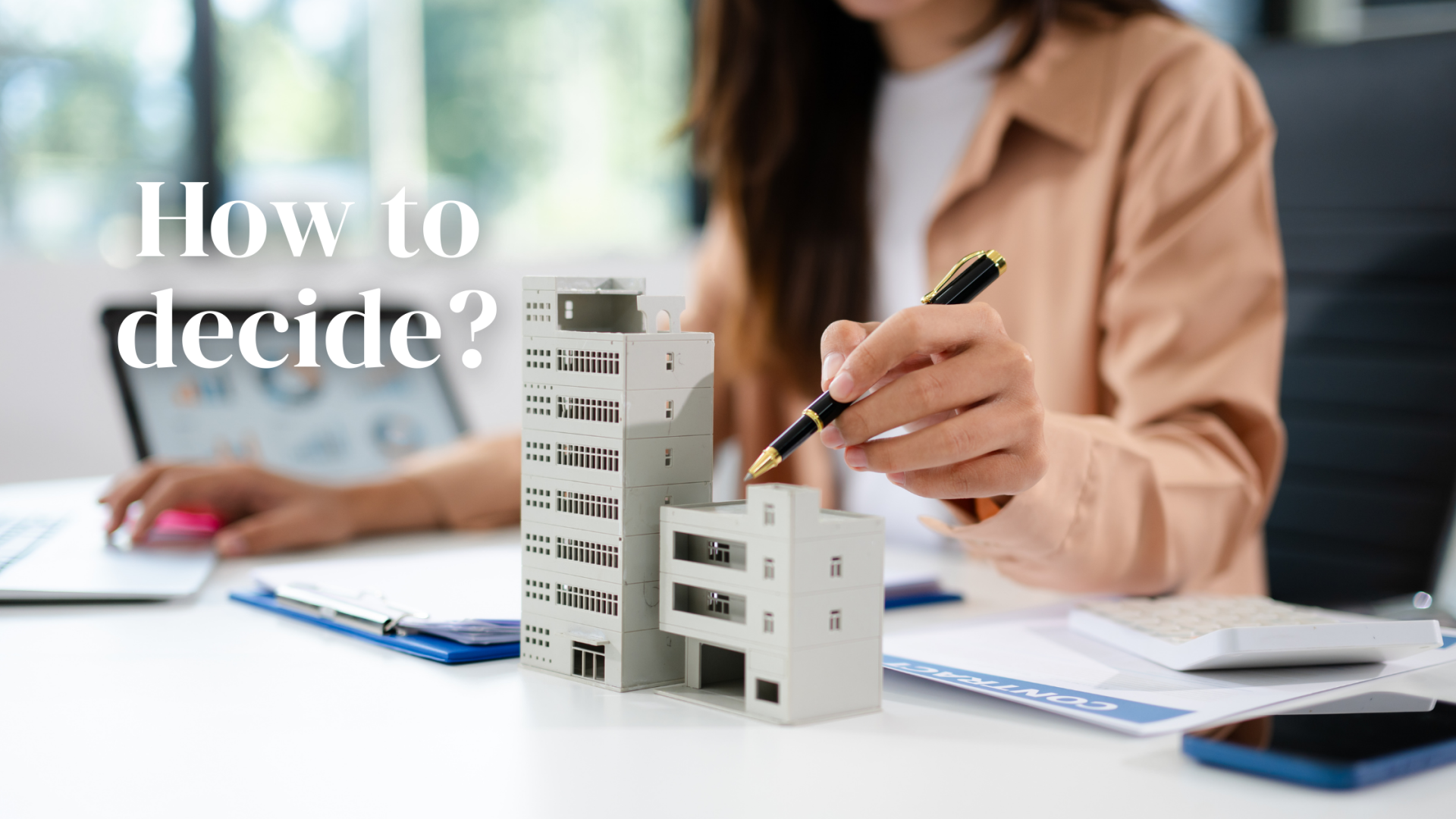 A person pointing to small model of flats