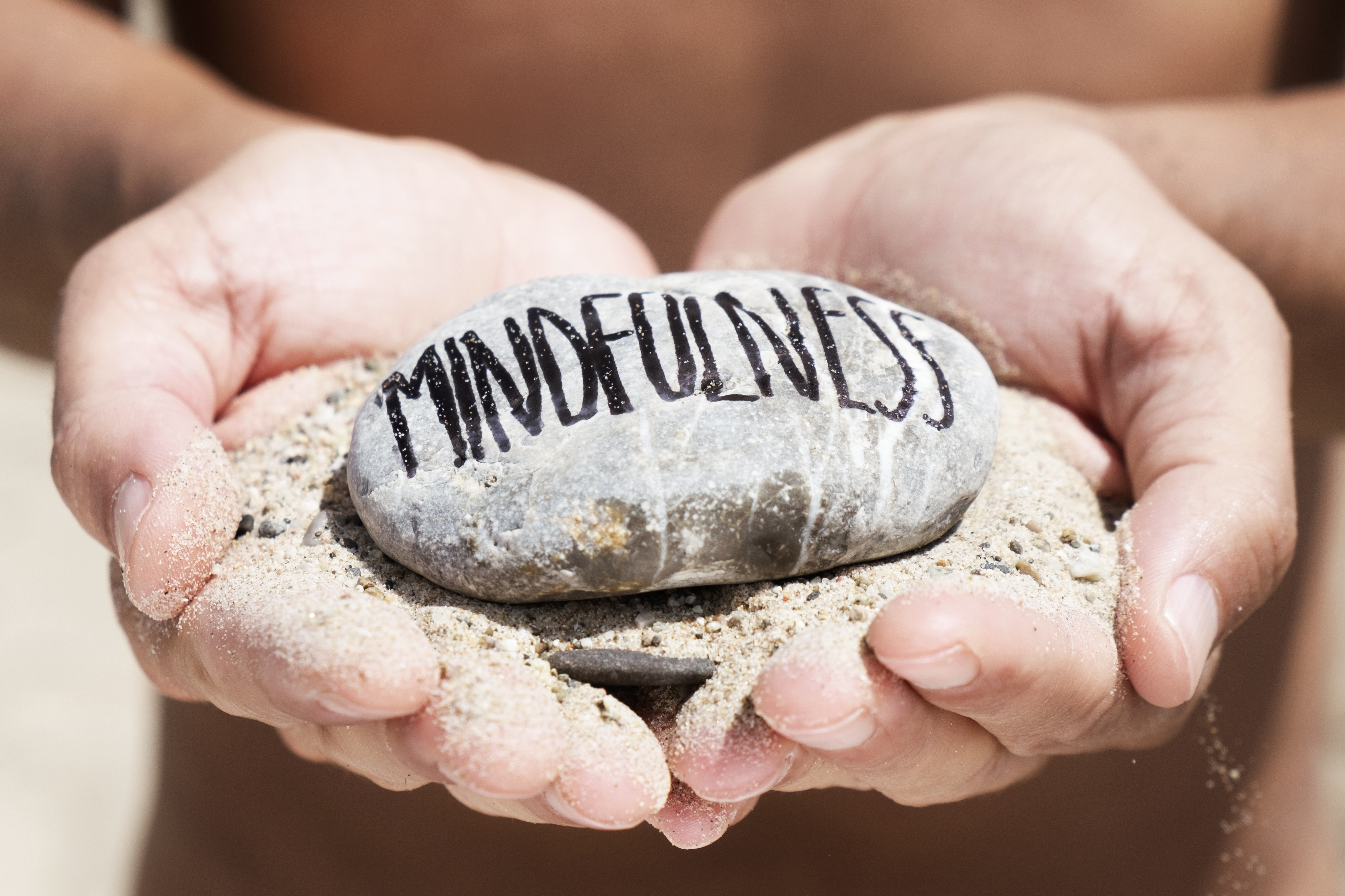 mindfulness sand holding pebble