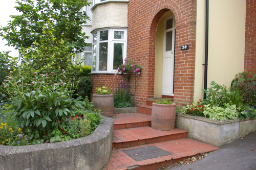 A garden in front of a brick buildingDescription automatically generated